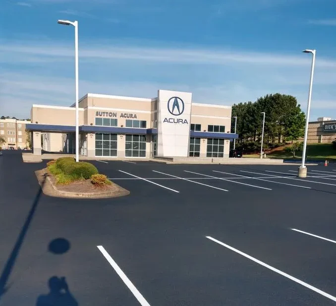 Newly coated and striped asphalt parking lot paved by Macon Asphalt Paving in front of Acura dealership