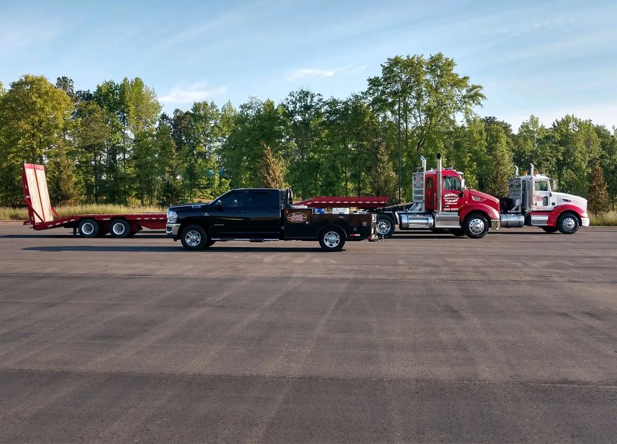 asphalt paving work trucks lined up for photo, two semi-trucks with flatbeds and F250